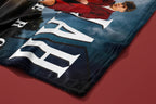 Close-up of a blue fabric with large white letters on a red surface