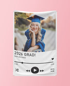 Graduation-themed decorative banner with a photo of a graduate and '2026 GRAD!' text on a pink background.