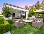 Outdoor patio area with furniture and a fireplace in a garden setting