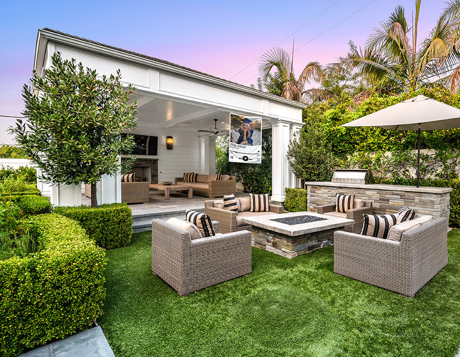Outdoor patio area with furniture and a fireplace in a garden setting