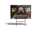 Graduation sign with a photo of a graduate and text on a stand.