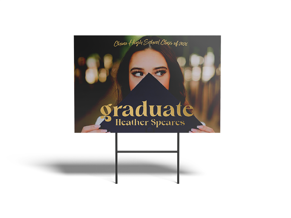 Graduation sign with a photo of a graduate and text on a stand.
